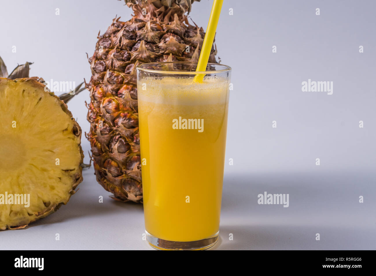 Front view the glass of pineapple juice and pineapple fruit over white ...
