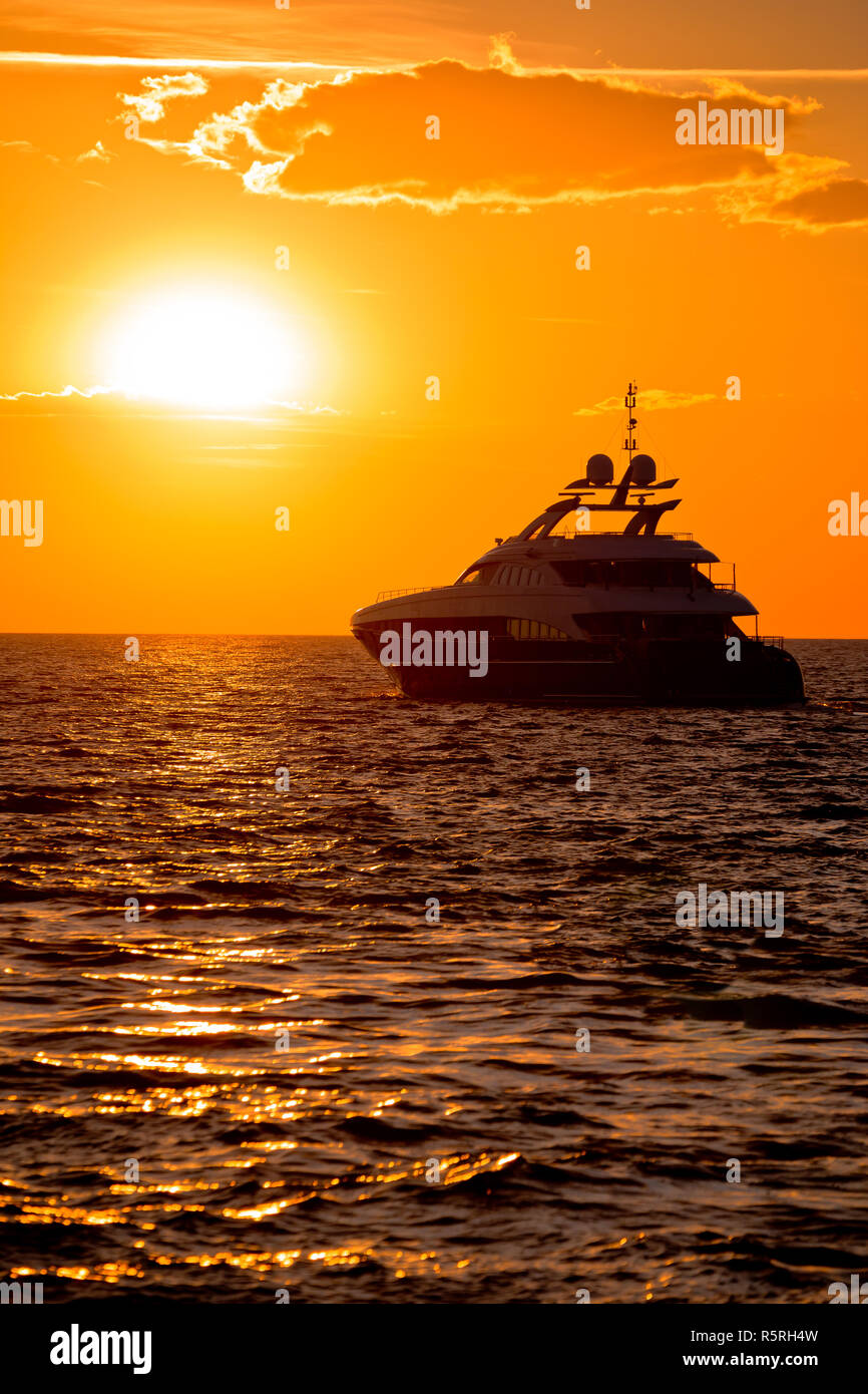Luxury yacht on open sea at golden sunset Stock Photo - Alamy