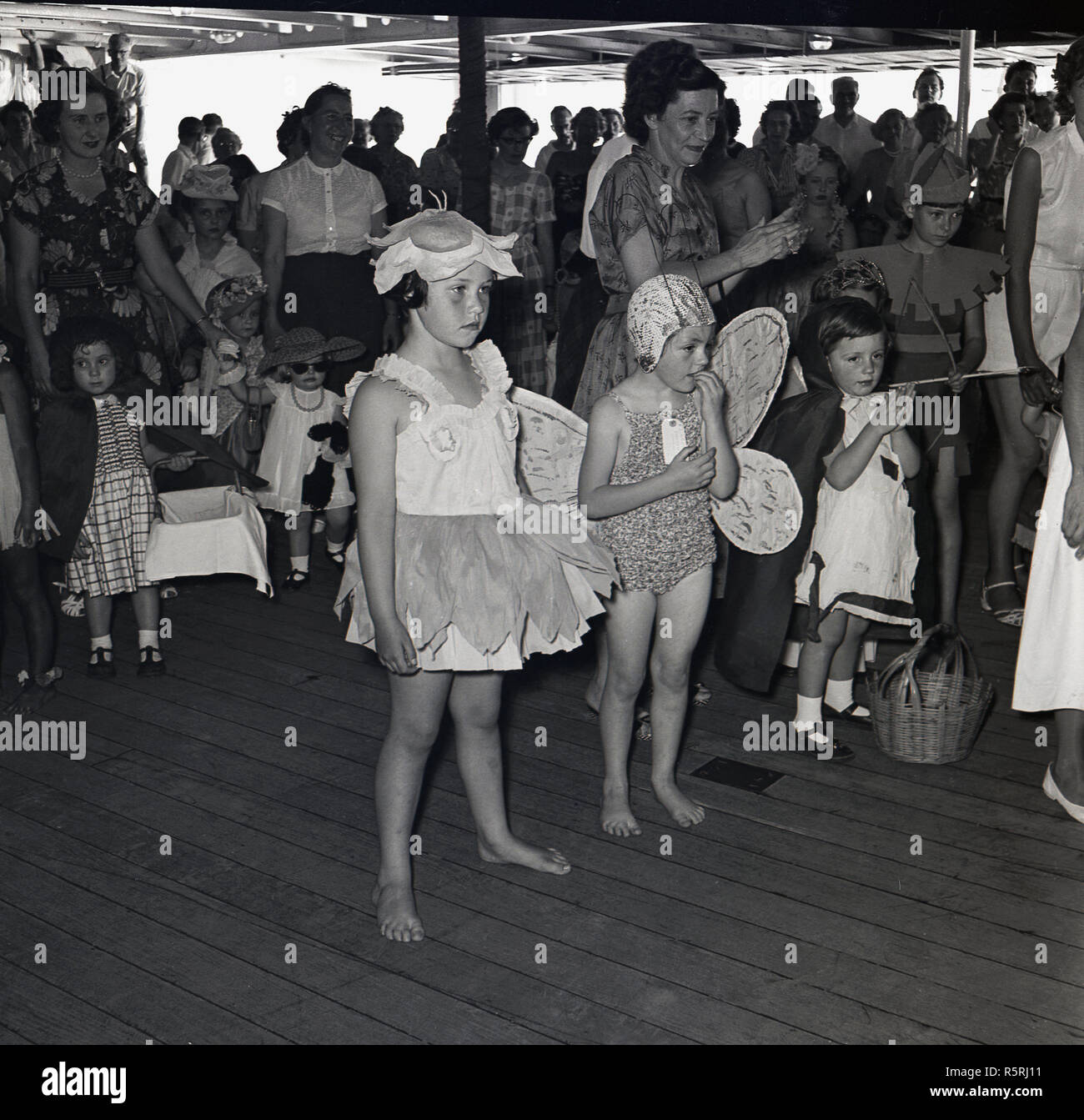 1950s, historical, on-board the union-castle steamship, a childrens fancy dress party taking place, watched by parents and other passengers. Stock Photo