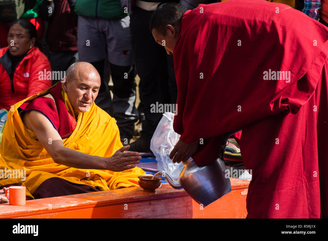 Buddhist monk pouring tea to another monk during the Empowerment or Wong ceremony at Mani Rimdu festival, Tengboche, Nepal Stock Photo