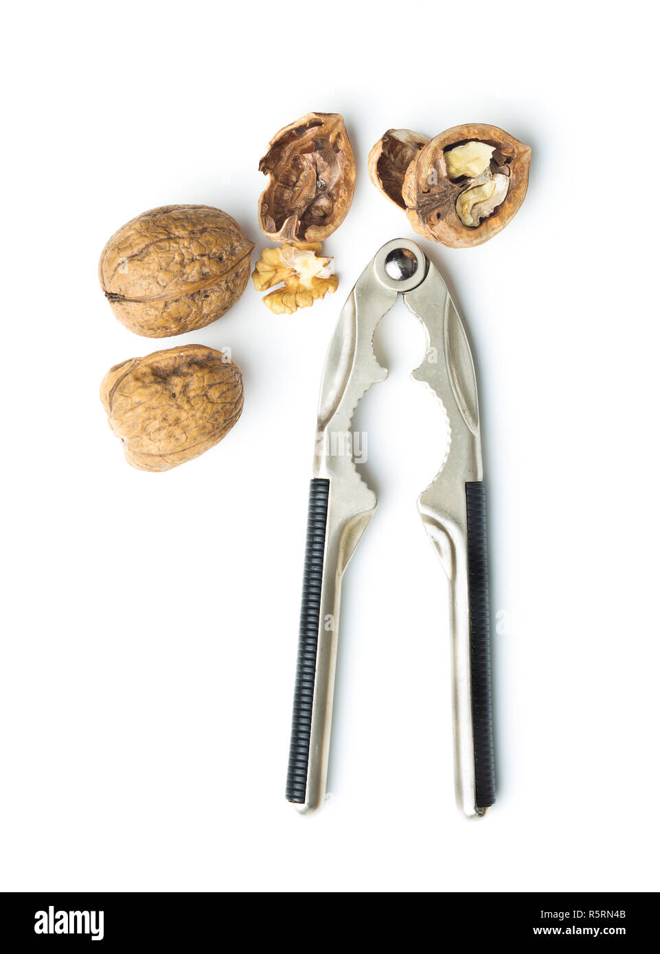 Cracked dried walnuts and nutcracker. Stock Photo