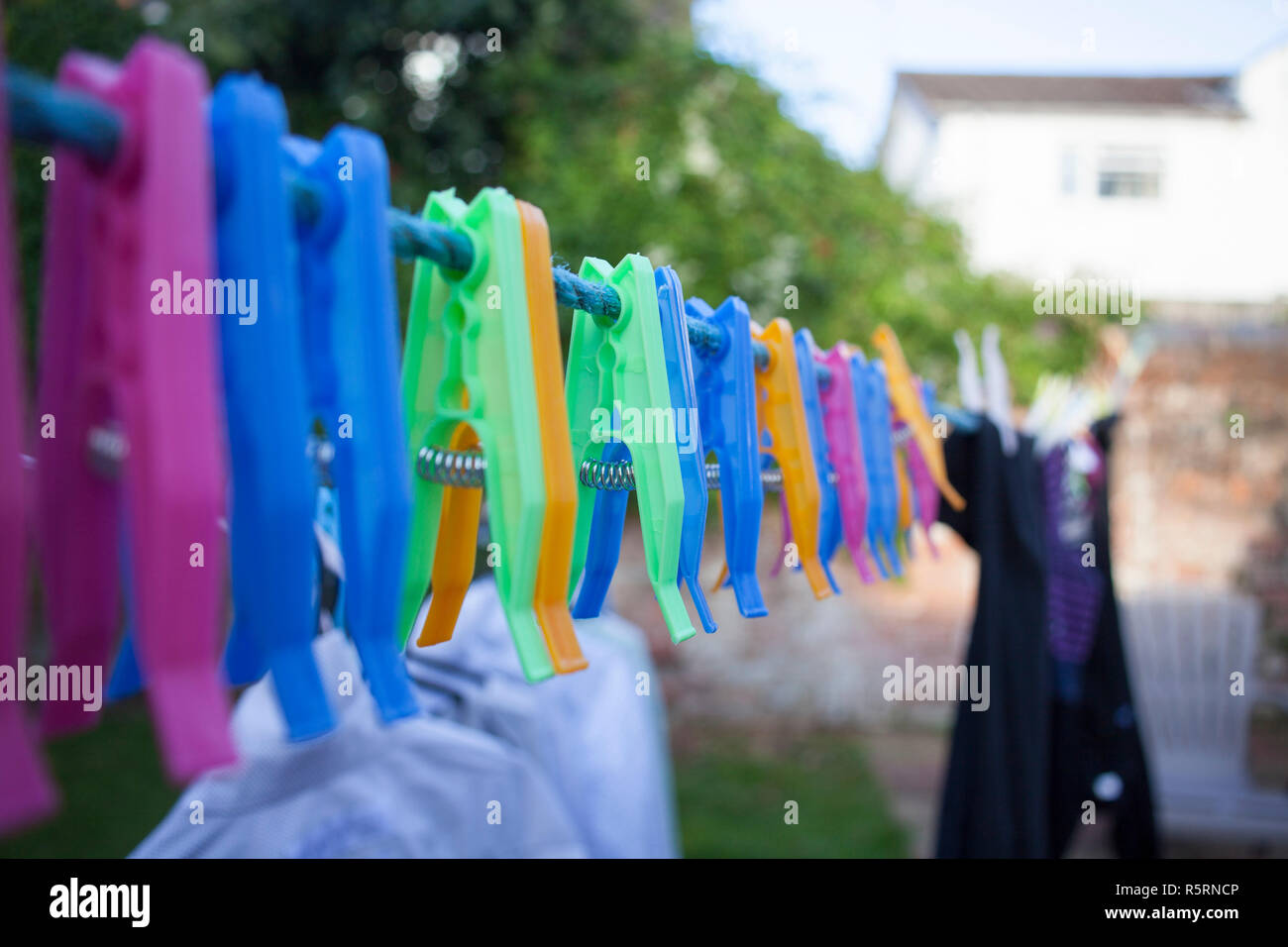 Plastic clothes pegs laying on the wire. Stock Photo