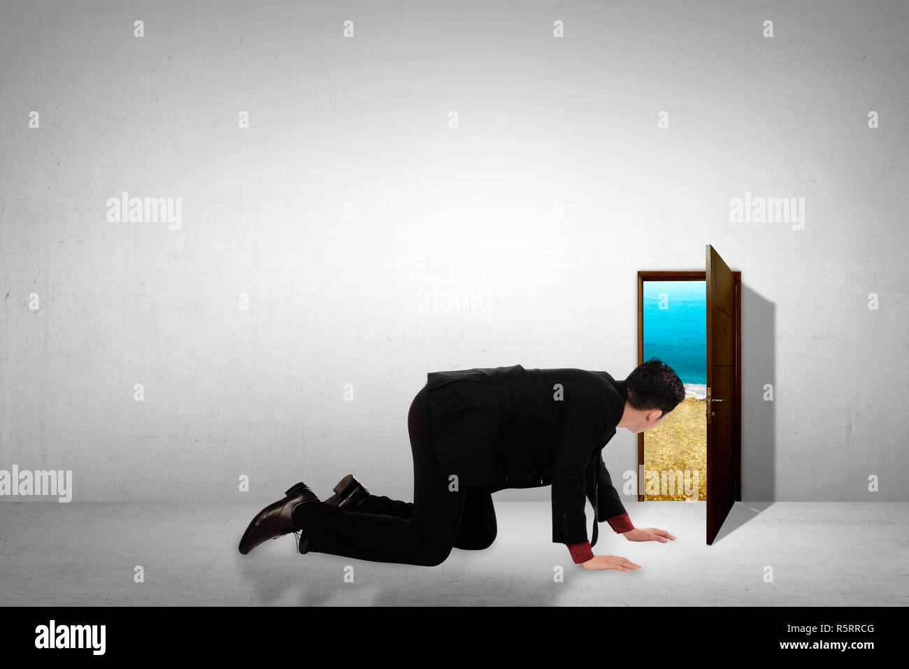 Business man take peek on small door through beach. Vacation opportunity concept Stock Photo