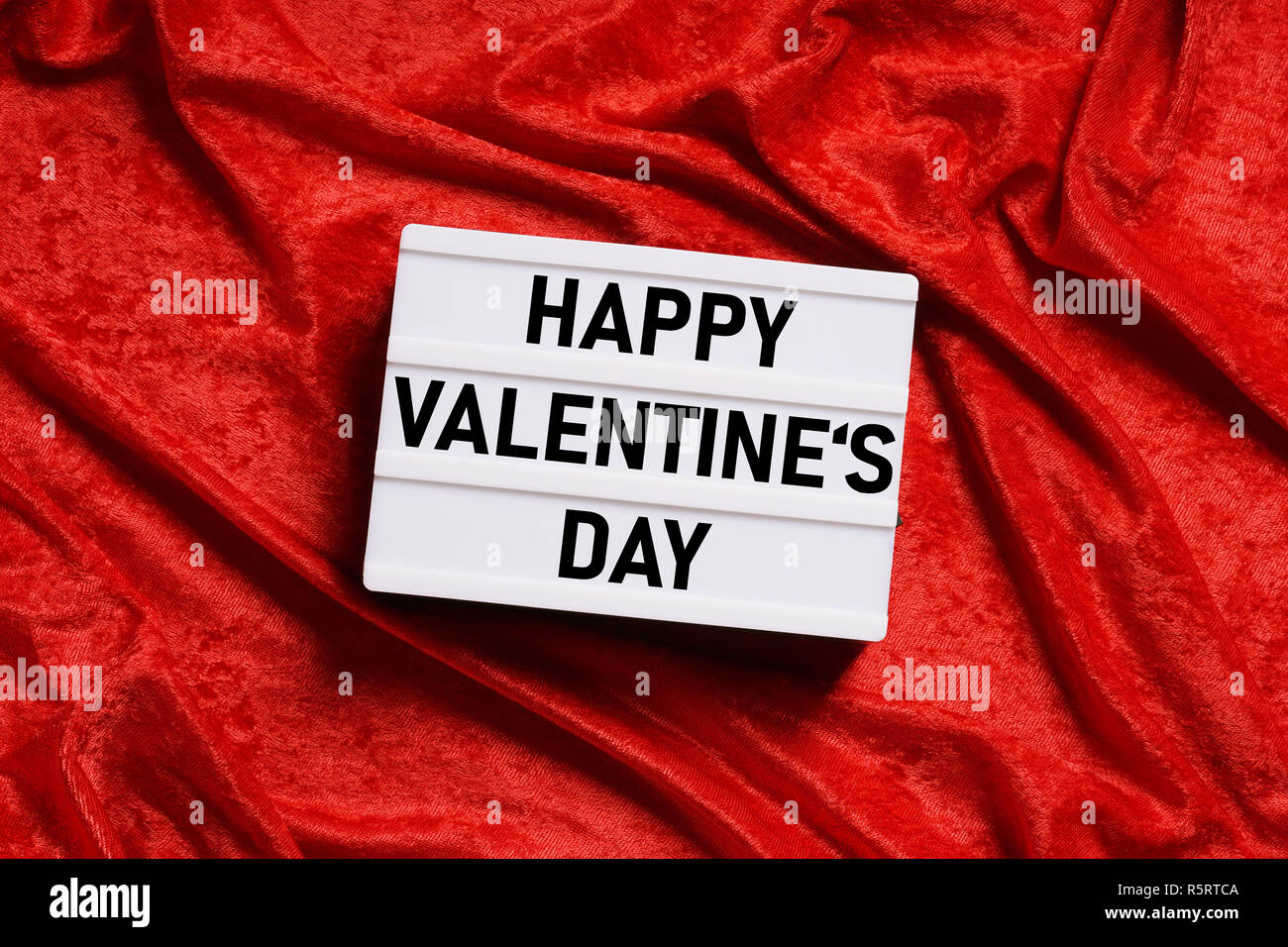 happy valentines day lightbox on red velvet background Stock Photo