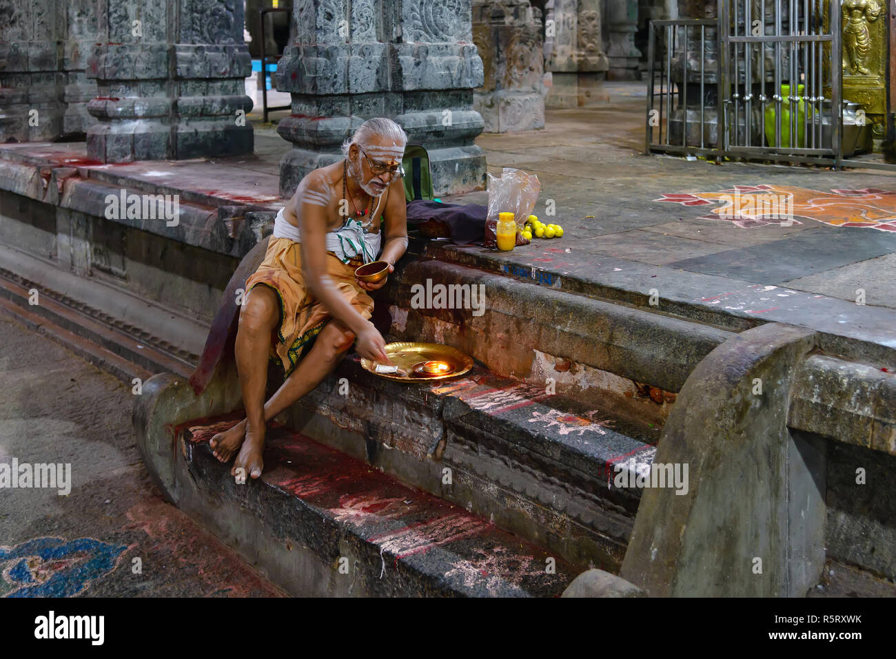 Kanchipuram, India - August 19, 2018: A brahmin sitted on steps perform an hindu ritual inside the Ekambareswarar temple in Tamil Nadu state Stock Photo