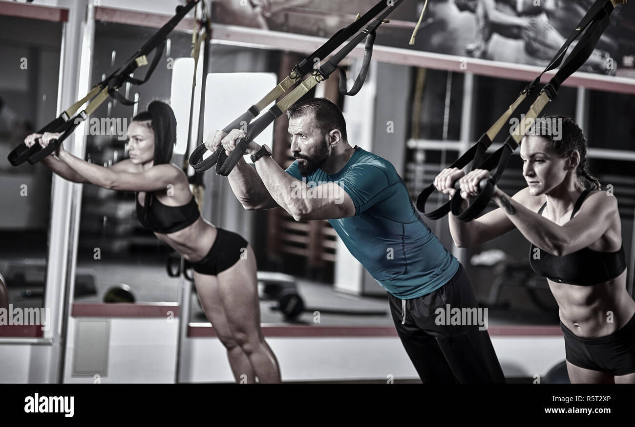 Athletic people doing crossfit training with trx straps Stock Photo - Alamy