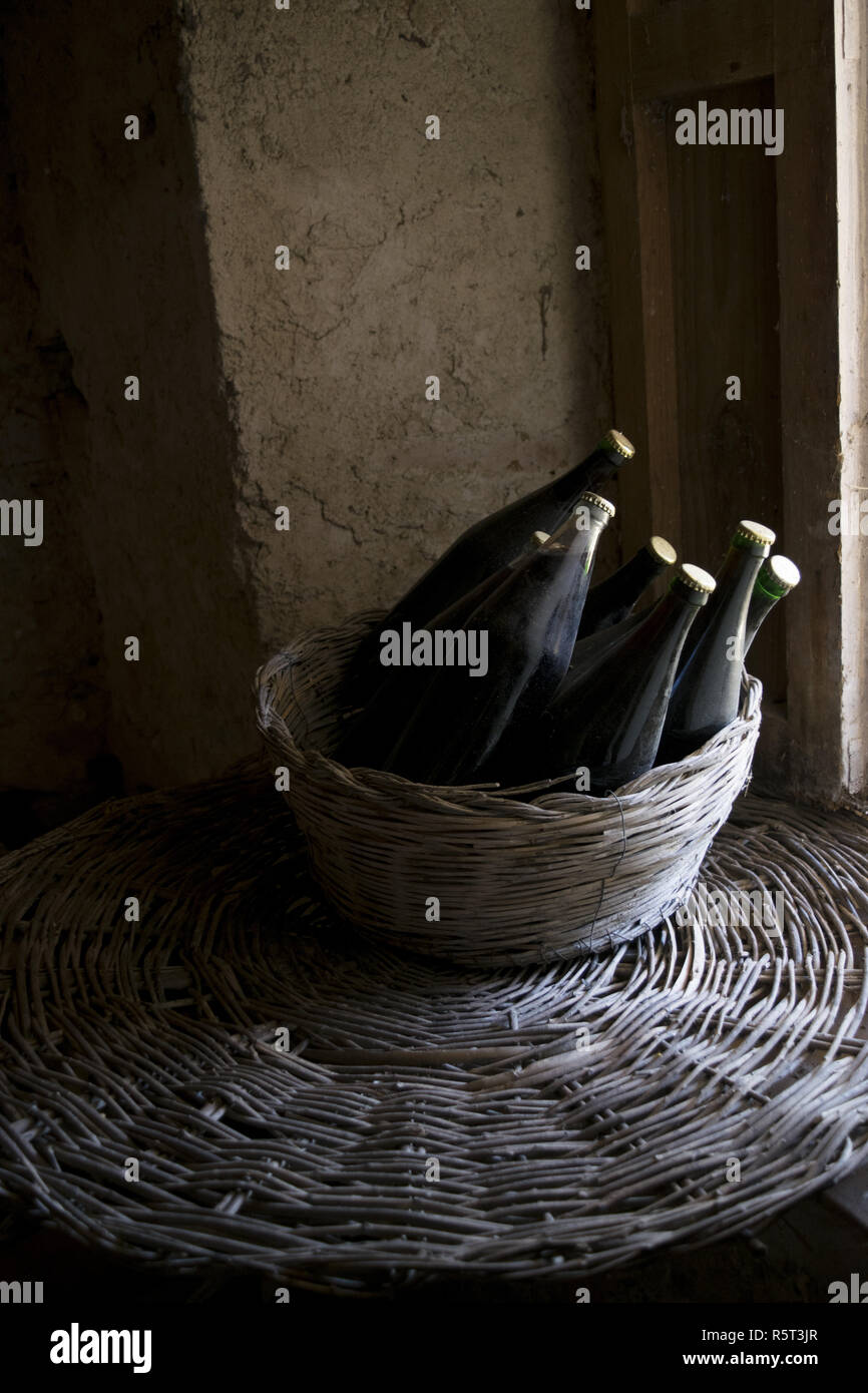 old red wine bottles in a wicker basket Stock Photo Alamy