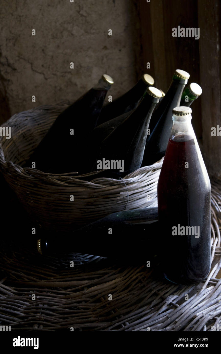 old red wine bottles in a wicker basket Stock Photo Alamy