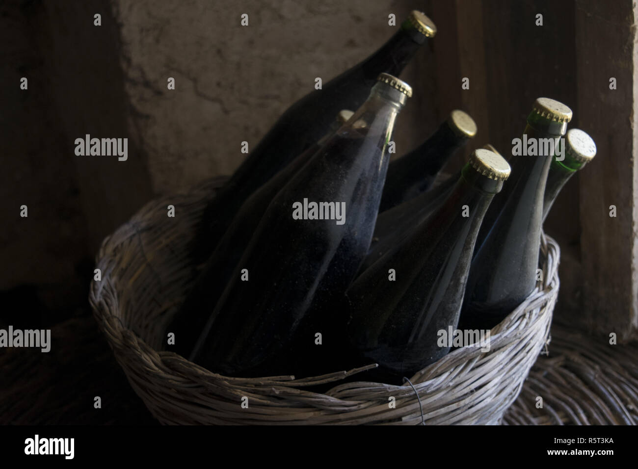 old red wine bottles in a wicker basket Stock Photo Alamy