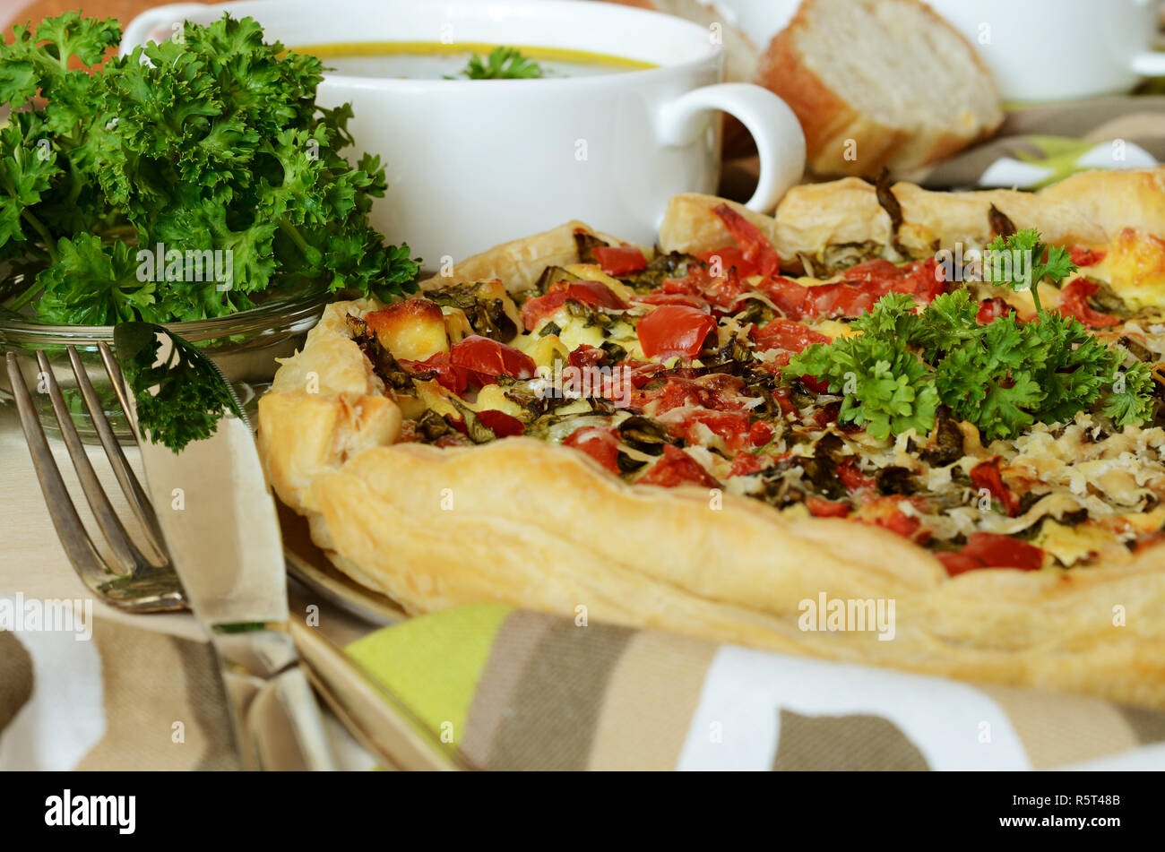 Pie of puff pastry with spinach, cheese and tomatoes for dinner Stock Photo