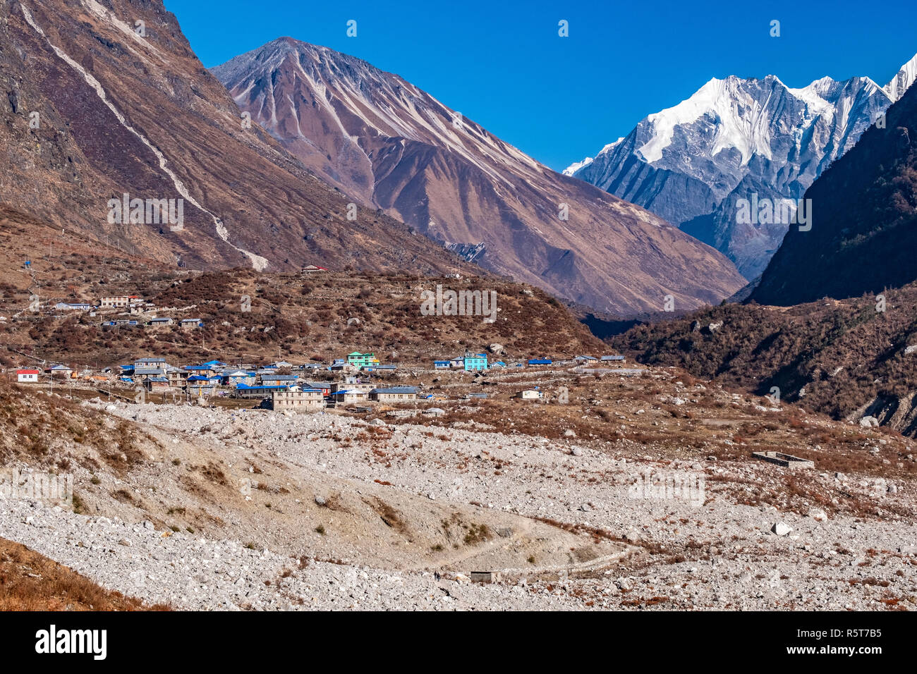 The photo shows the Langtang village, which is rebuilt after the earthquake 2015. The foreground shows the rubbish of the earthquake, which has burrie Stock Photo