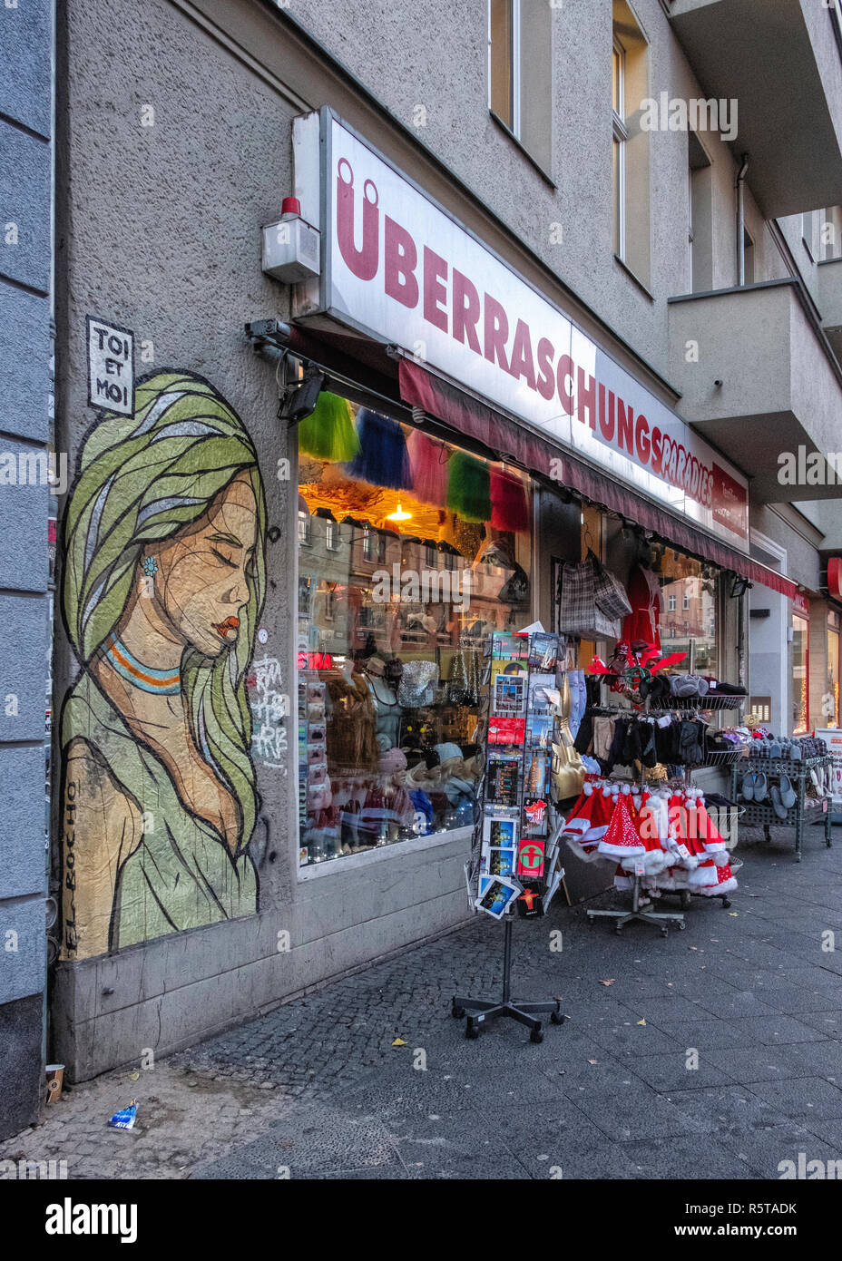 Berlin, Prenzlauer Berg street scene. Street art by artist El Bocho and novelty shop Stock Photo