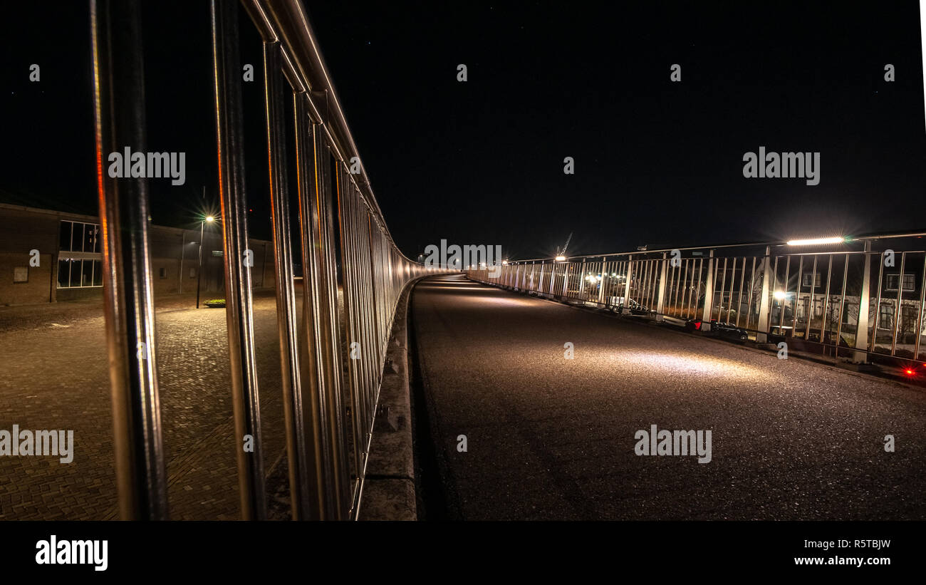 Illuminated walkway with metal silver balustrade in a curve shape Stock