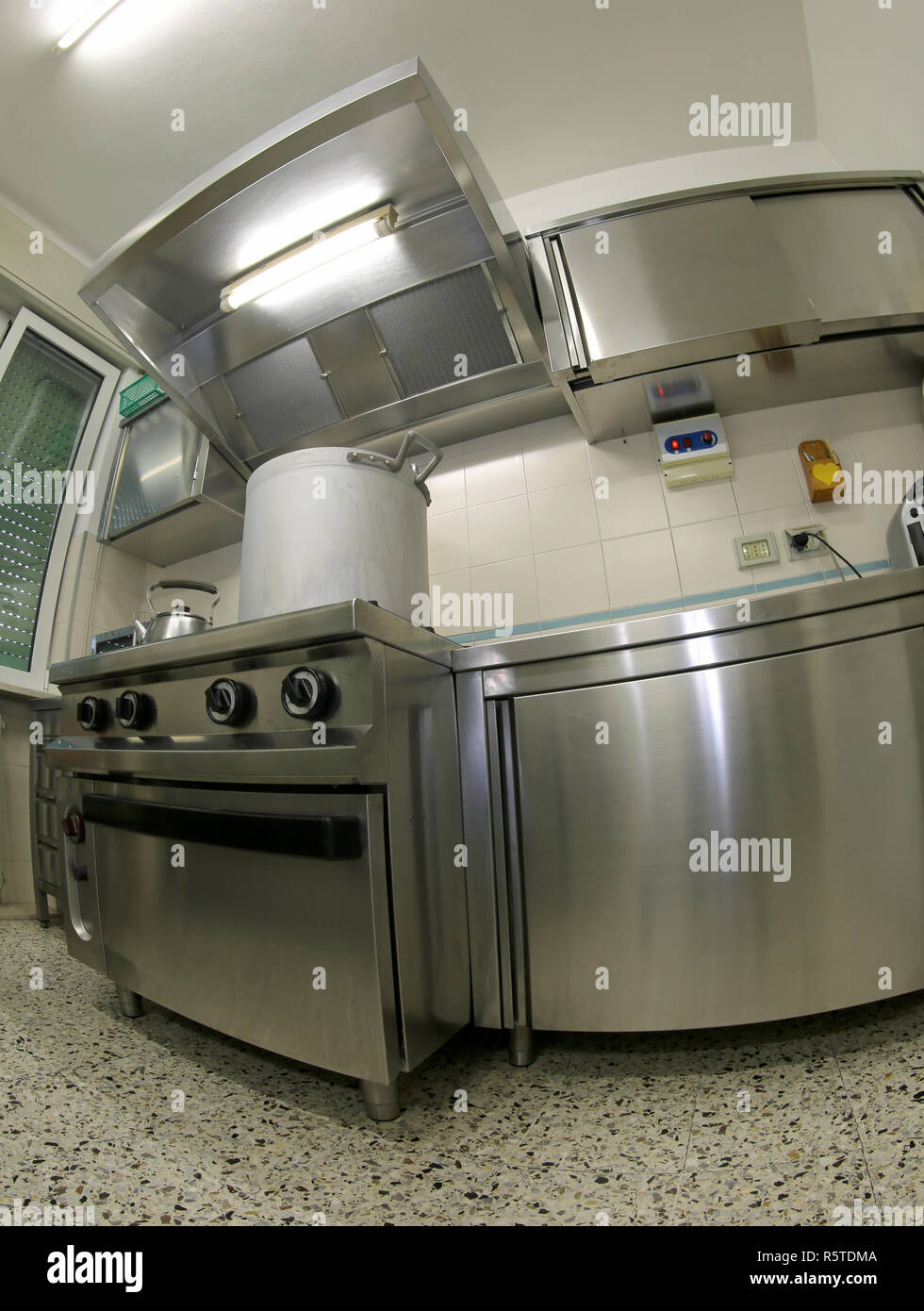 giant aluminum pot above the gas stove in the large industrial kitchen