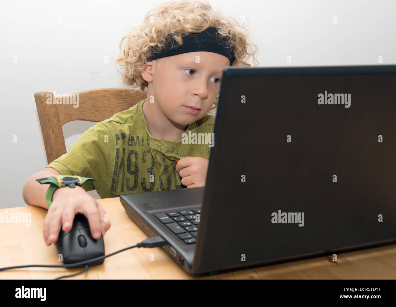 Portrait of a little blond boy using a laptop Stock Photo - Alamy