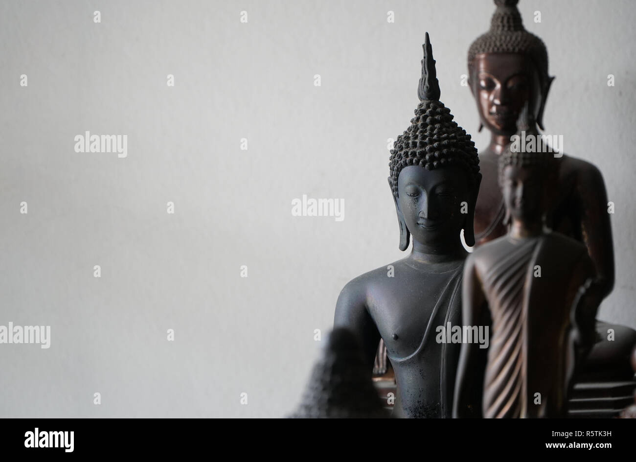 select focus of vintage black ancient buddhas statue in the middle of other buddhas statue Stock Photo