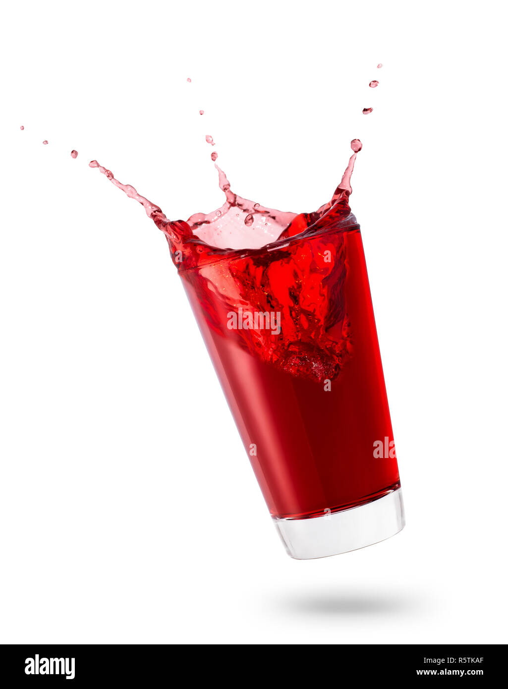 falling glass of red juice or berry compote with splashes isolated on ...