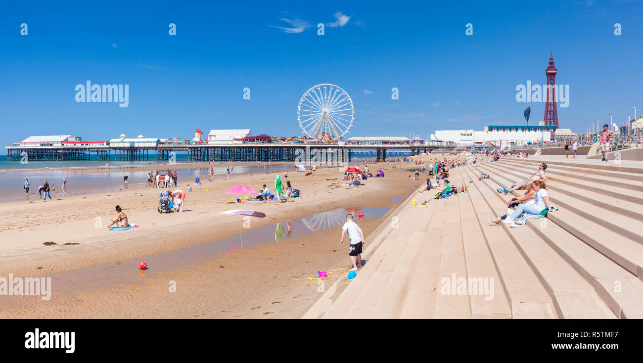 Blackpool uk people on the sandy beach Blackpool beach summer with Blackpool tower and central pier Blackpool Lancashire England UK GB Europ Stock Photo