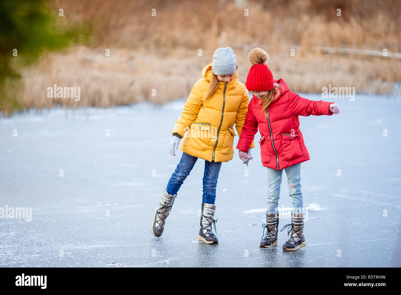 Adorable little girls skating on the icerink Stock Photo Alamy