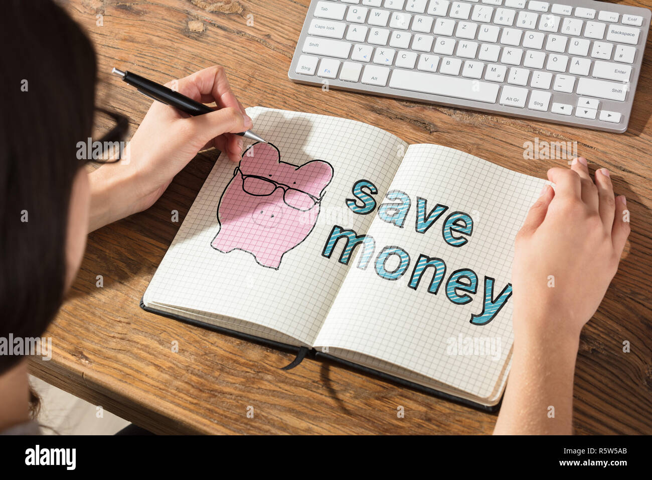 Woman Writing On Checker Note Book Stock Photo