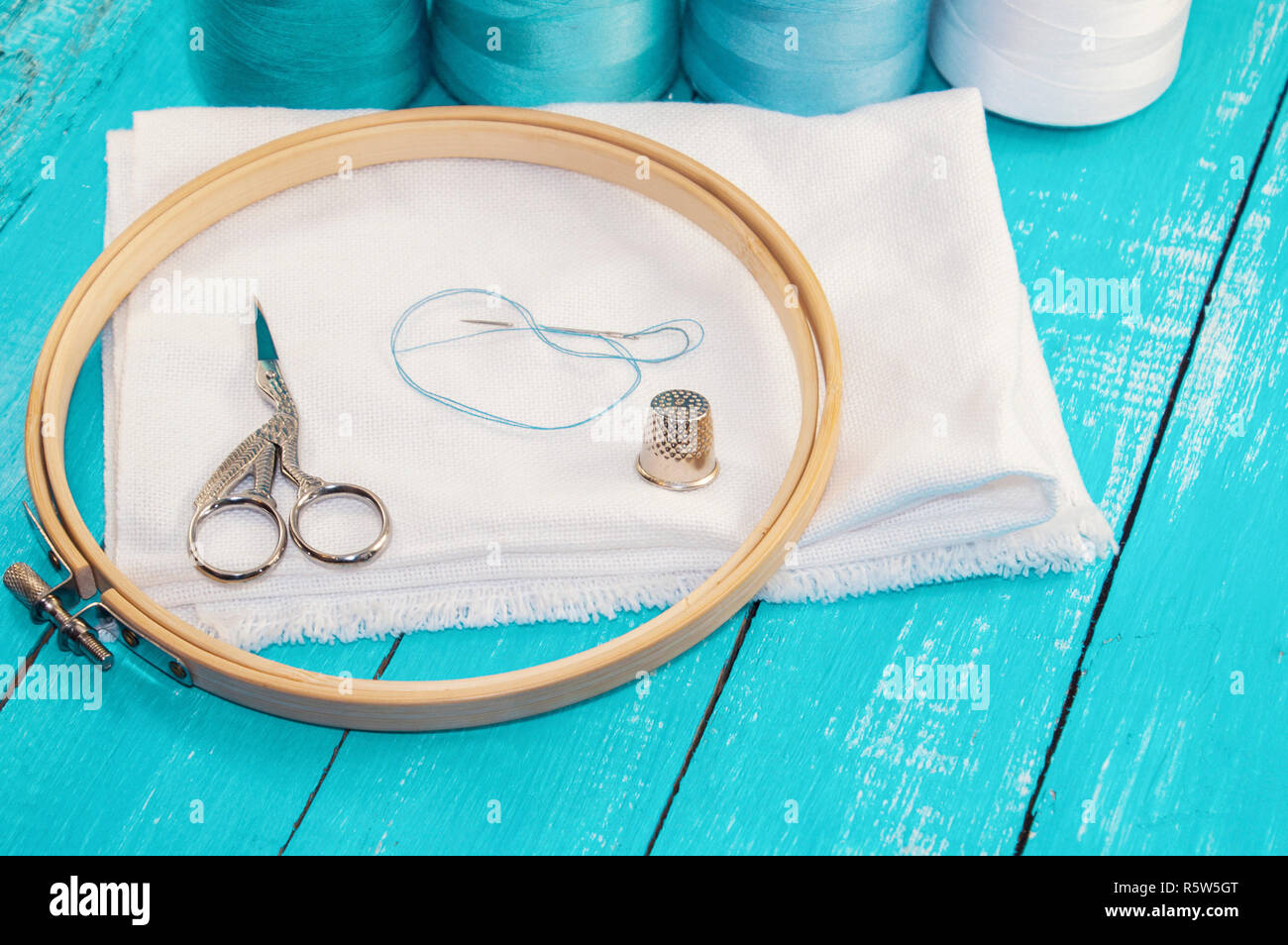 wooden round embroidery frame and white fabric for cross stitching