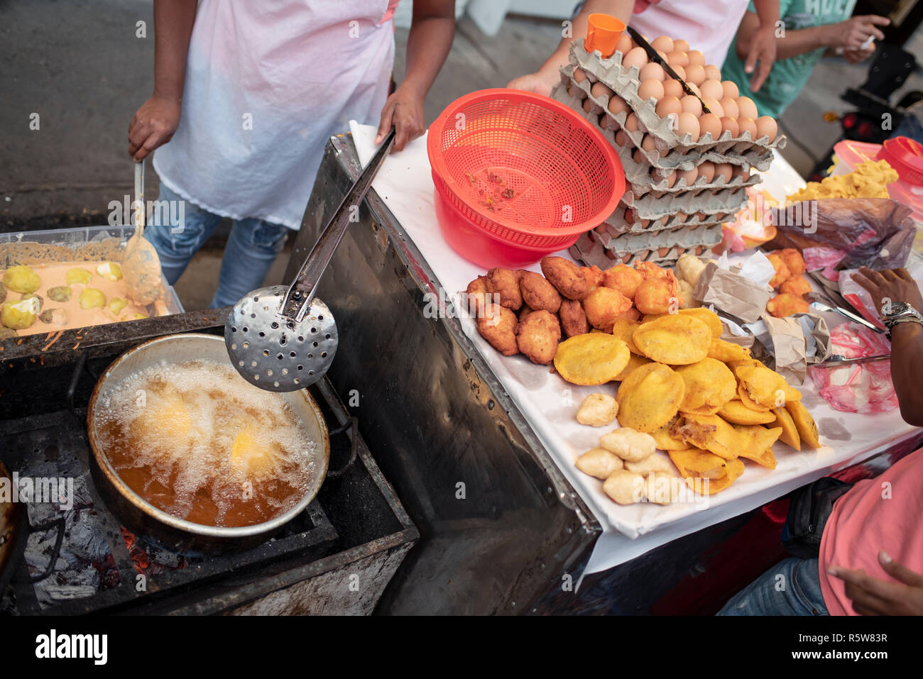 Fried street food in the making. Yuca, potato, patacones with costeño (plantains with soft cheese) and arepa with egg. Cartagena de Indias, Colombia Stock Photo