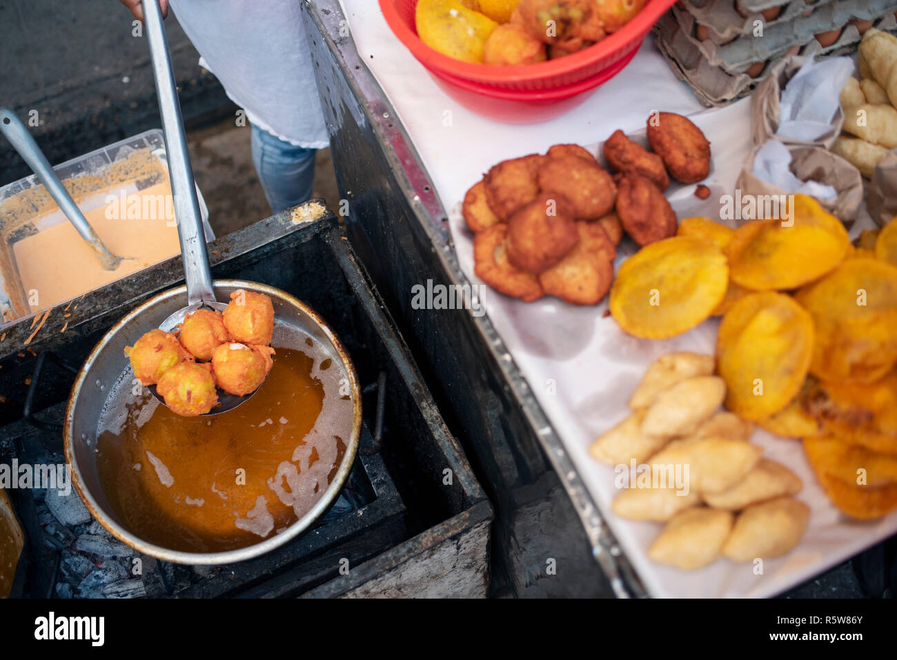 Fried street food in the making. Yuca, potato, patacones with costeño (plantains with soft cheese) and arepa with egg. Cartagena de Indias, Colombia Stock Photo