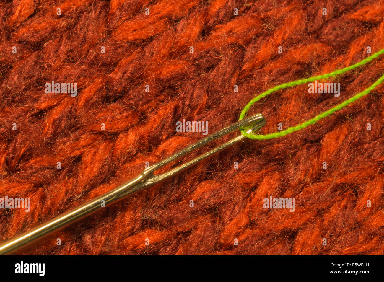 Needle with thread macro on textile background Stock Photo - Alamy