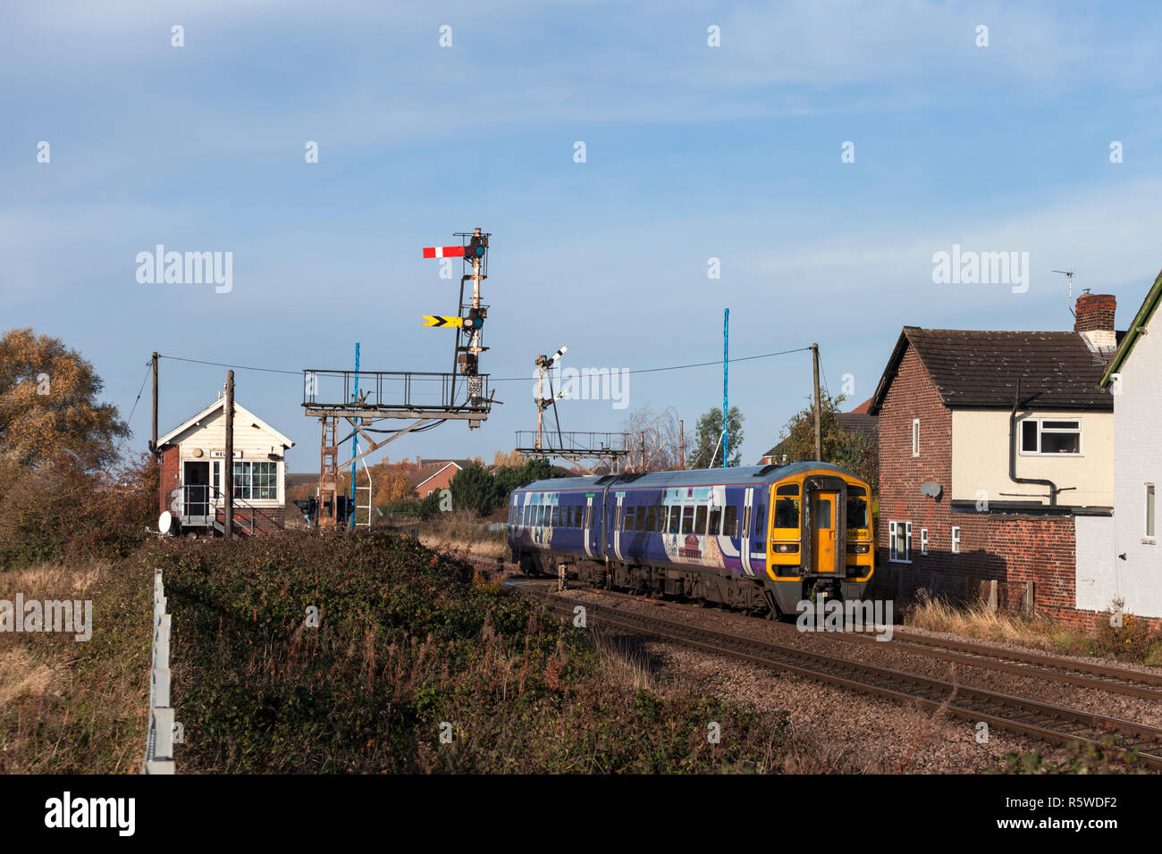 Arriva Northern rail class 158 sprinter train passing the mechanical signal box & semaphore signals at Welton, Humberside running on a RMT strike  day Stock Photo