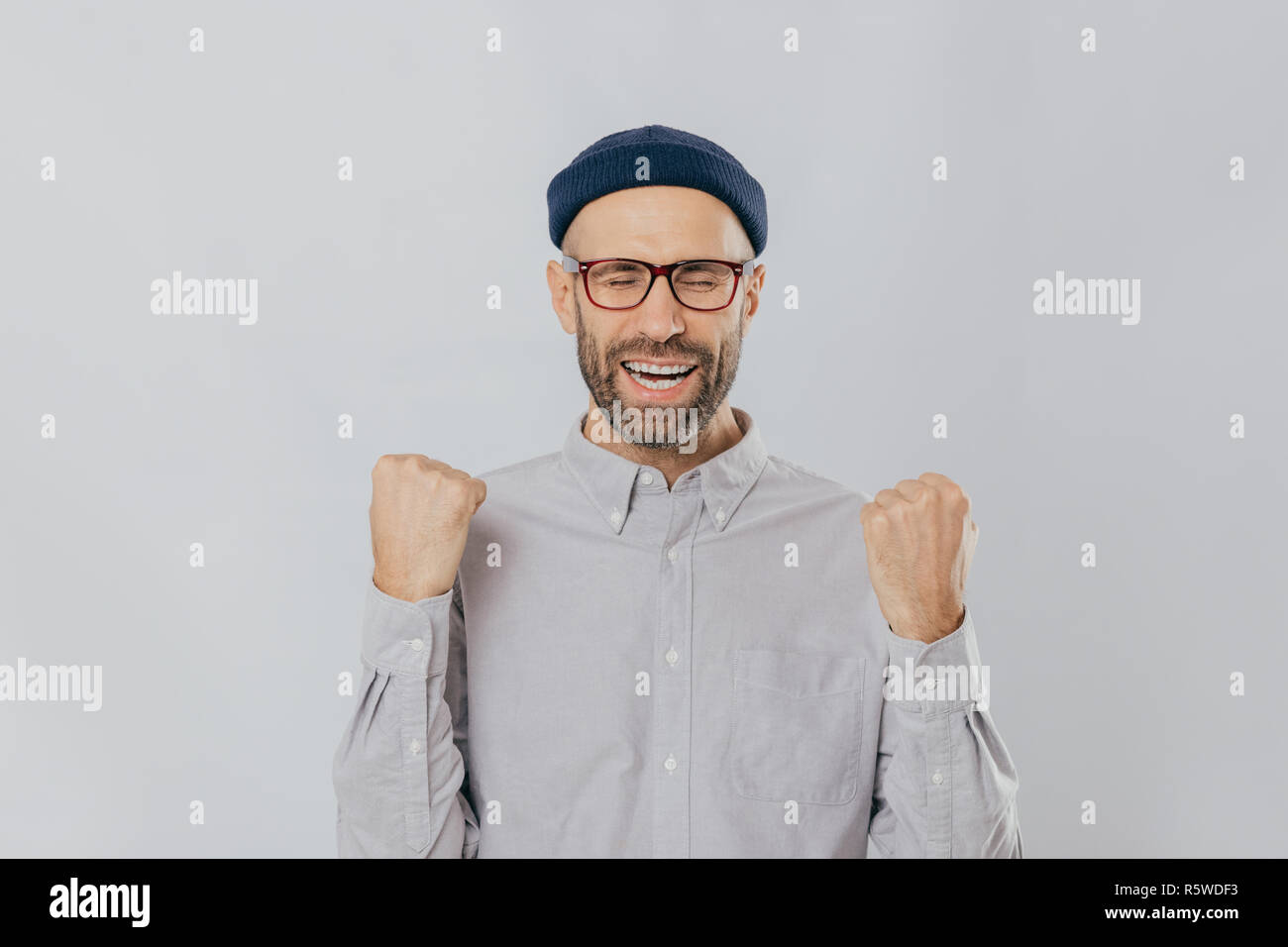 Gesture of success. Jubilant overjoyed unshaven man raises clenched
