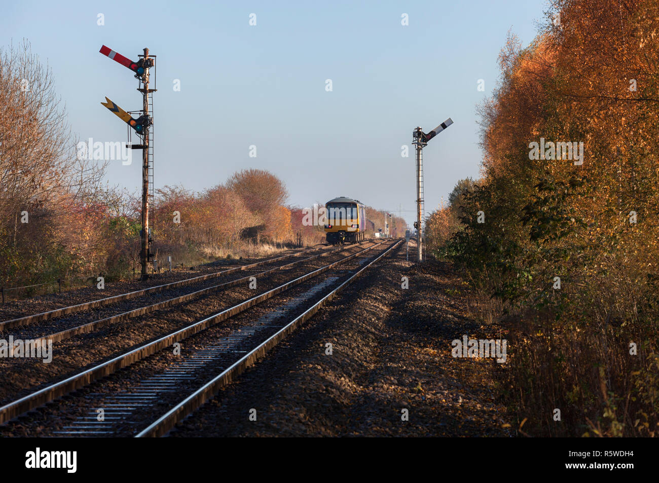 Arriva Northern rail class 144 pacer train passing the mechanical semaphore railway signals at Gilberdyke showing both home and distant signals Stock Photo