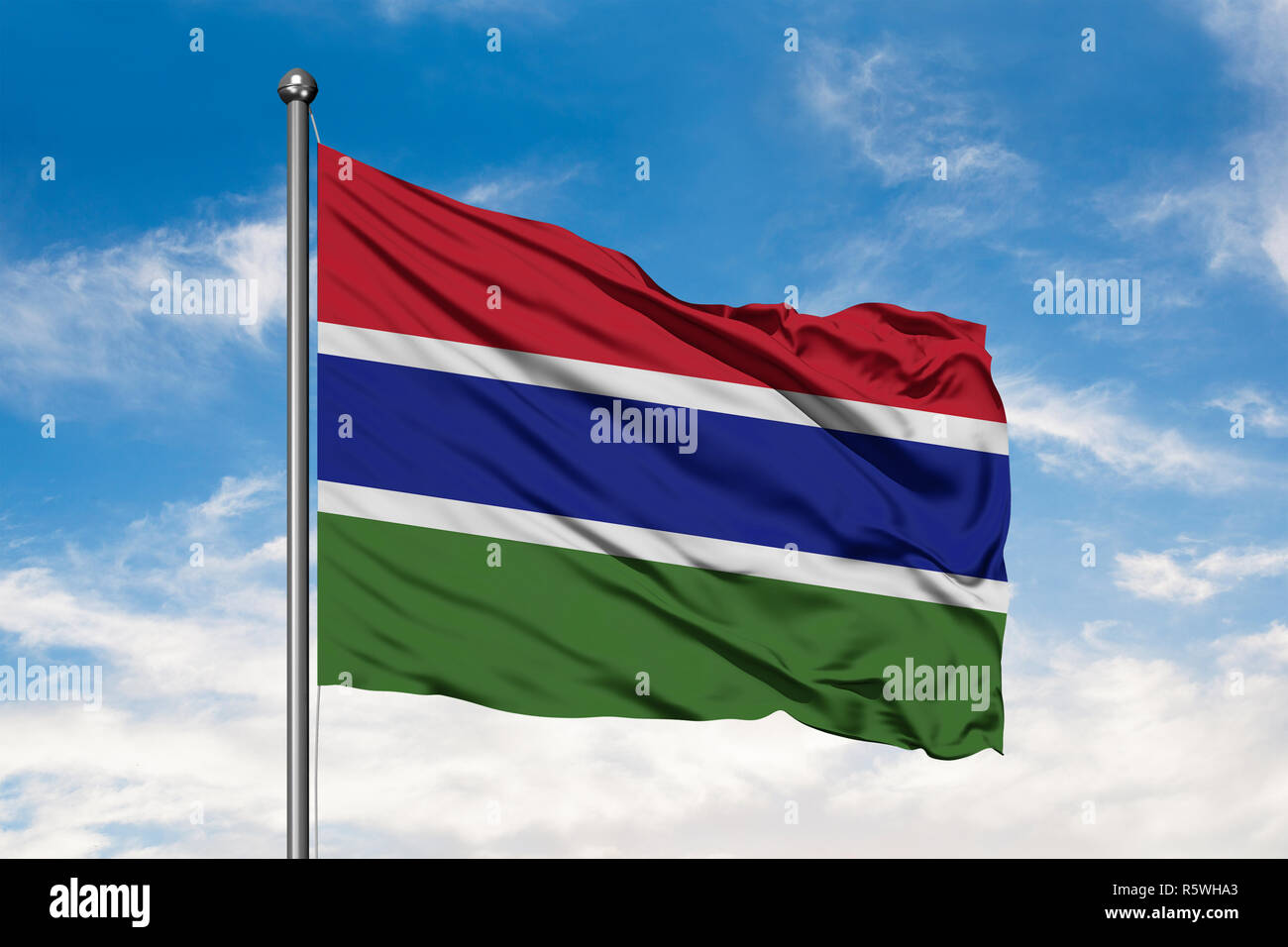 Flag of Gambia waving in the wind against white cloudy blue sky ...