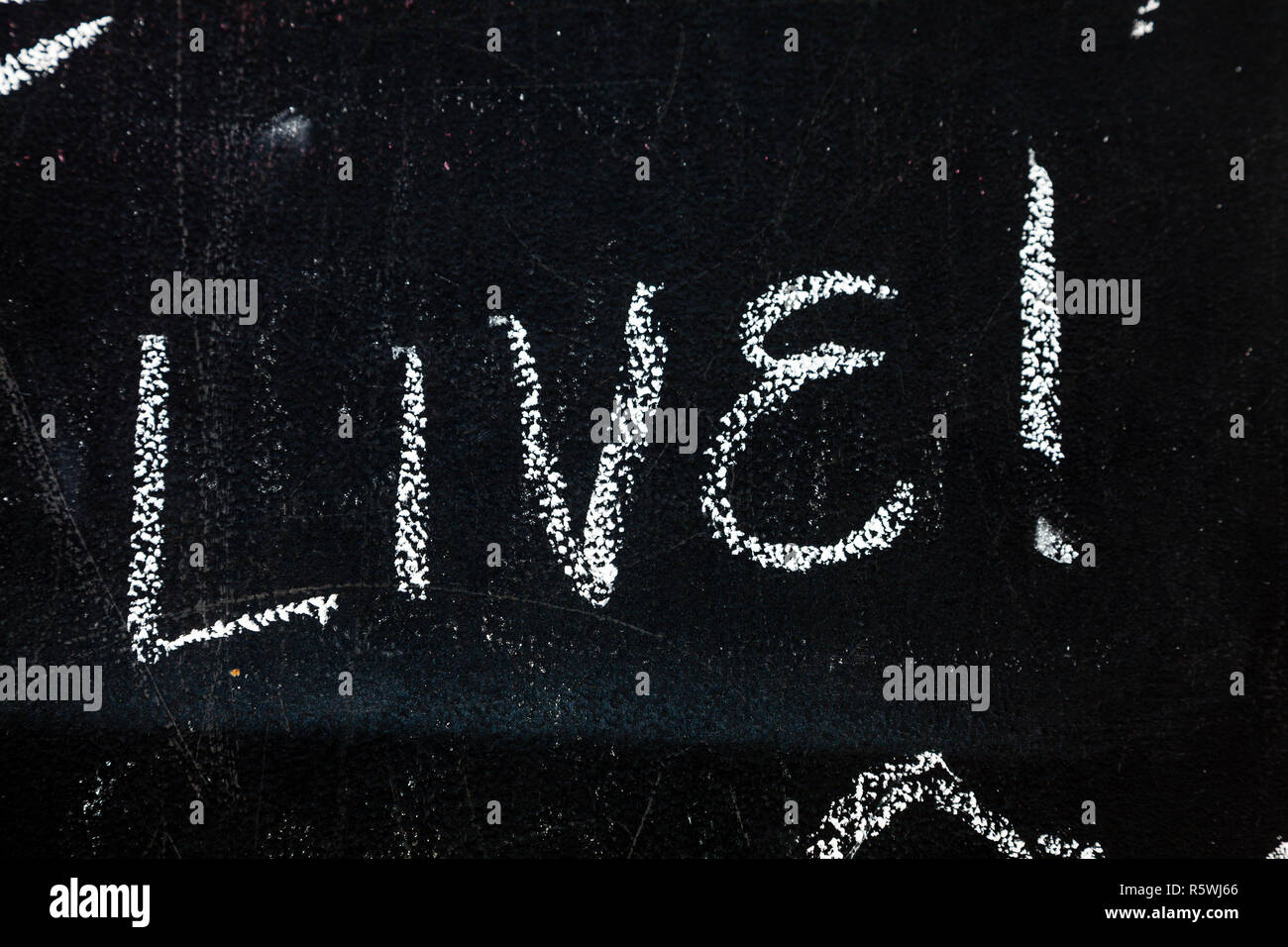 Fragment of a blackboard with text Live hand-written with chalk Stock Photo