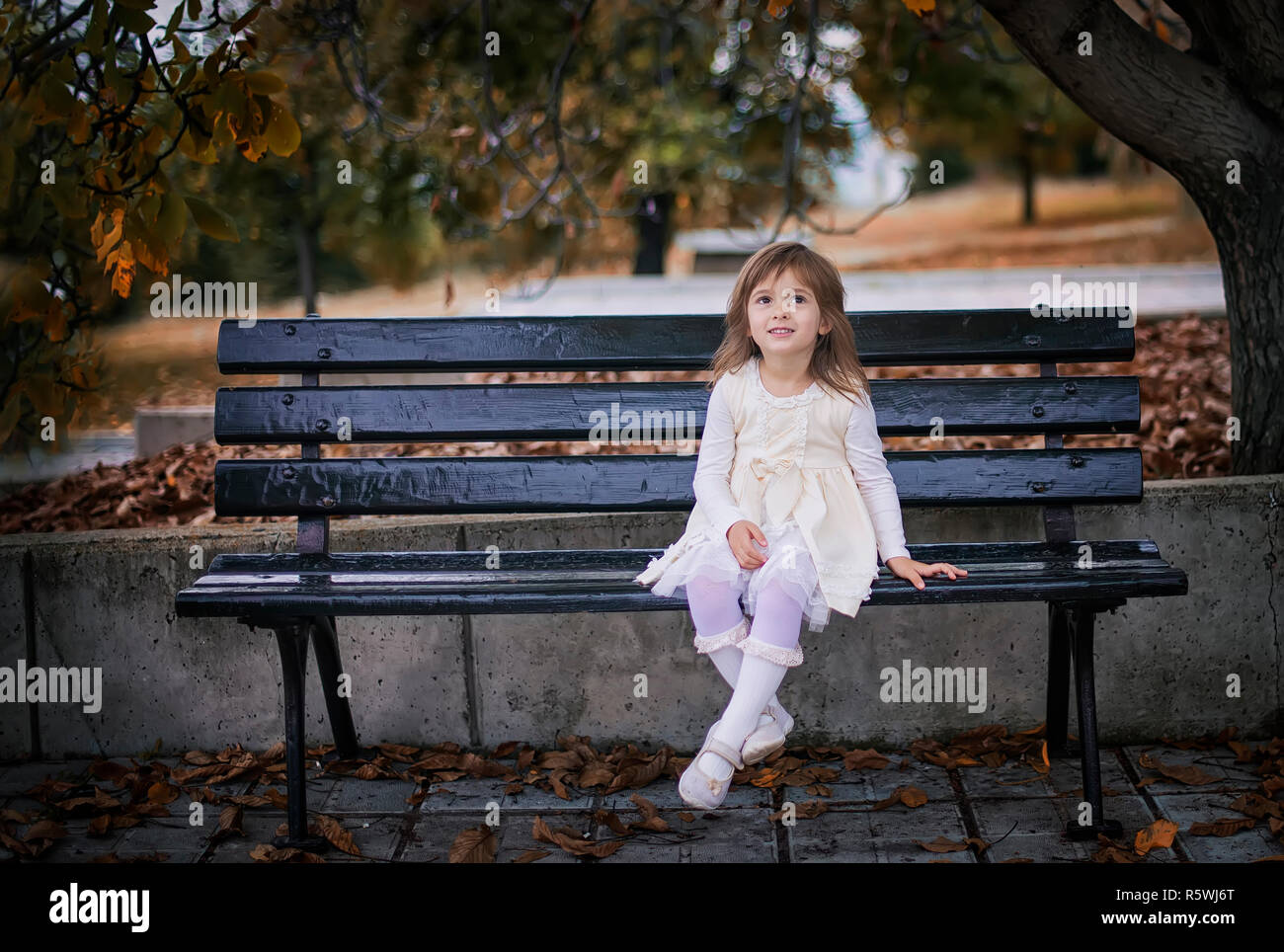 Girl sitting on a bench in the park, Bulgaria Stock Photo