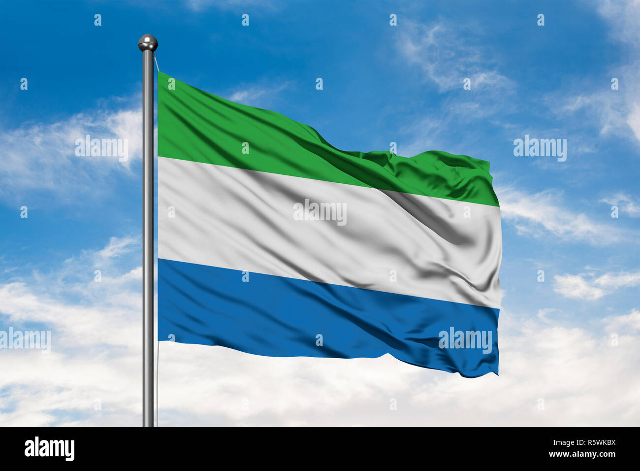 Flag of Sierra Leone waving in the wind against white cloudy blue sky ...