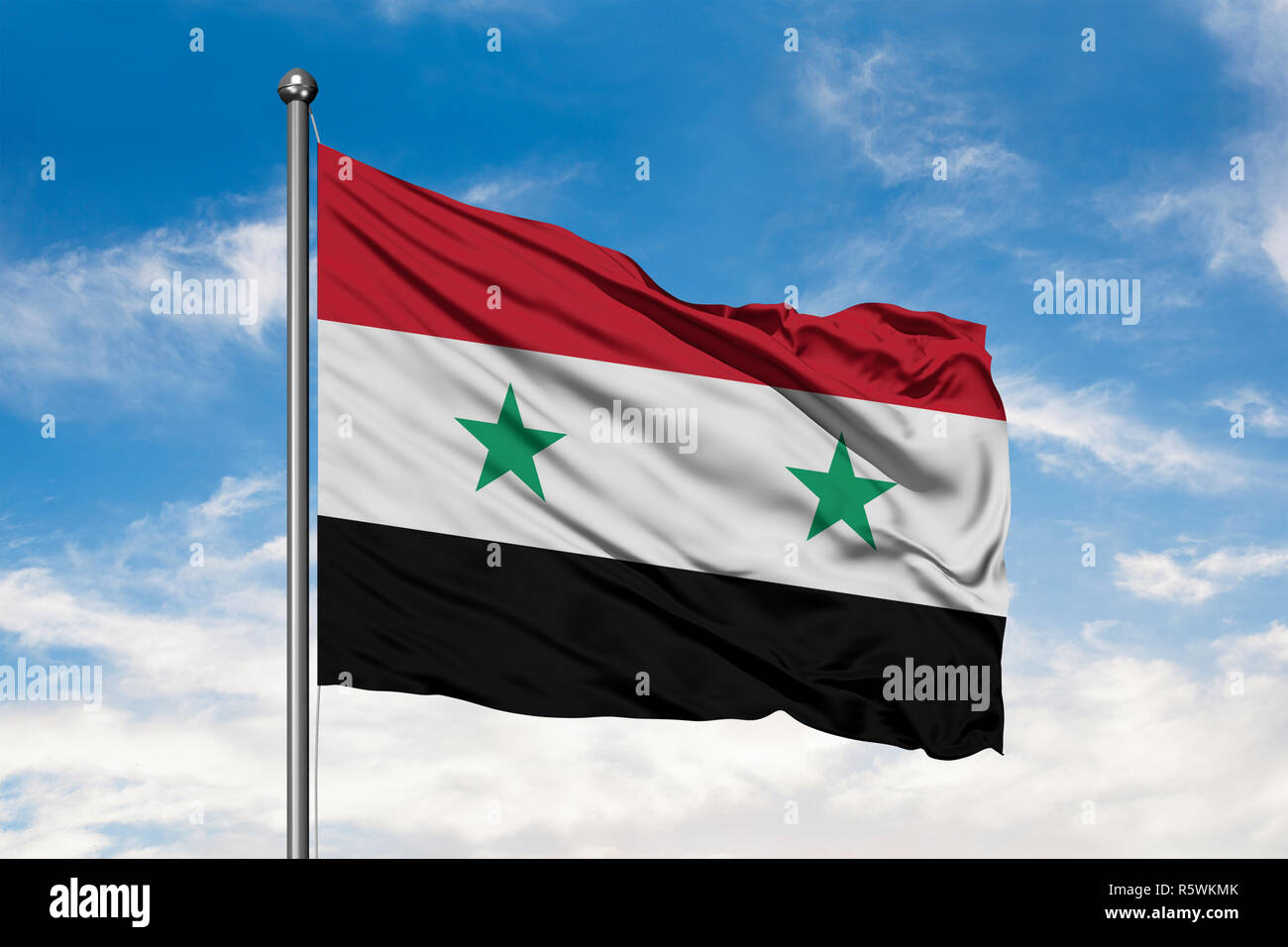 Flag of Syria waving in the wind against white cloudy blue sky. Syrian flag. Stock Photo