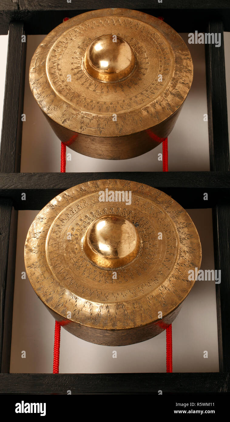 Bonang, kettle or pot gongs. Kulintang gongs or gong-chime from Malaysia, suspended on ropes stretched on a black wooden frame. Stock Photo