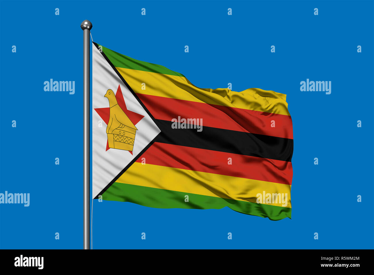 Flag of Zimbabwe waving in the wind against deep blue sky. Zimbabwean ...