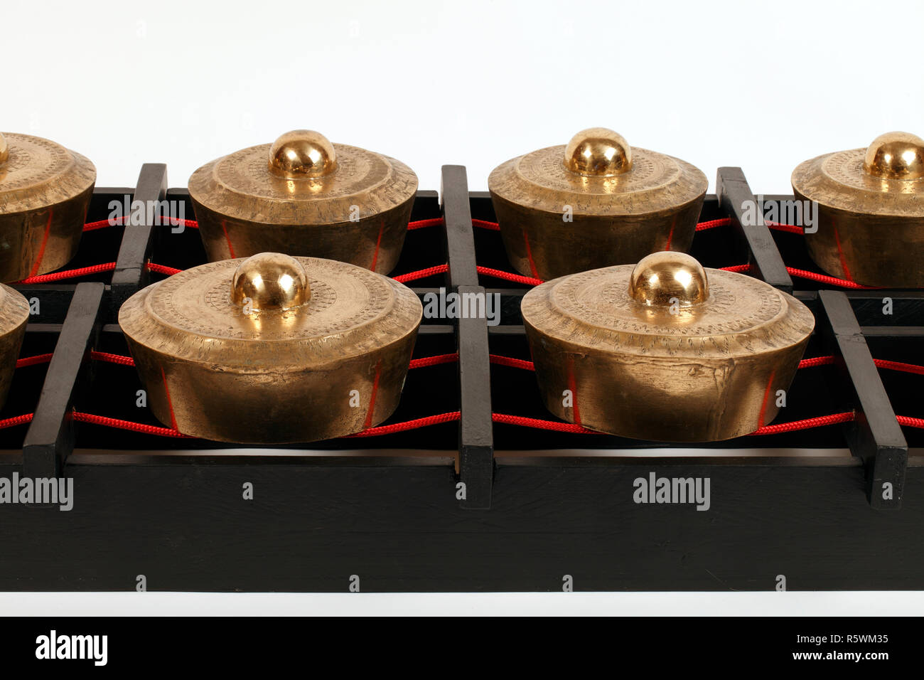 Bonang, kettle or pot gongs. Kulintang gongs or gong-chime from Malaysia, suspended on ropes stretched on a black wooden frame. Stock Photo