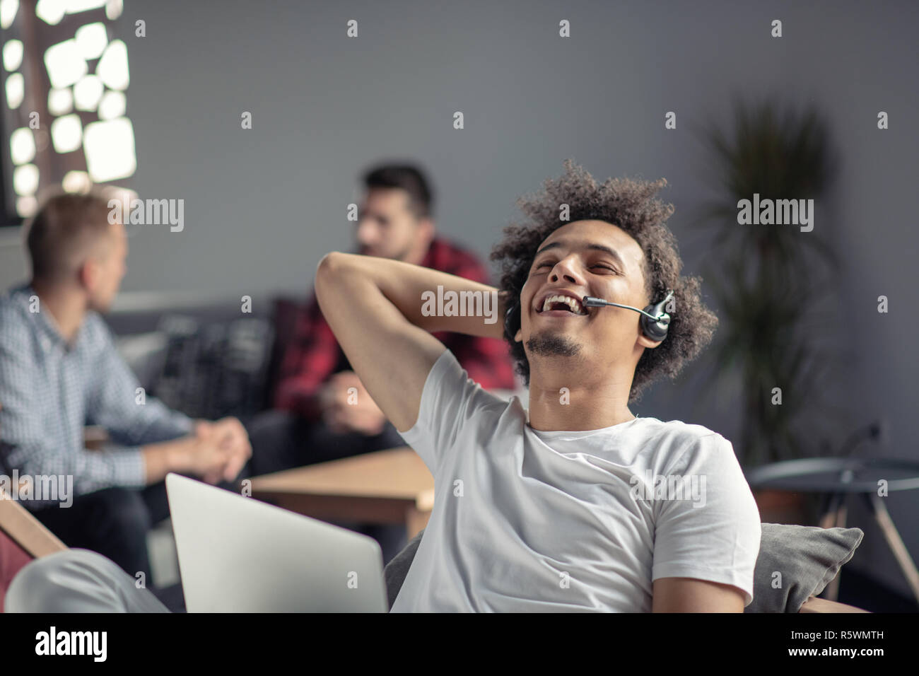 Laughing african american hipster software developer at computer at office of startup company Stock Photo