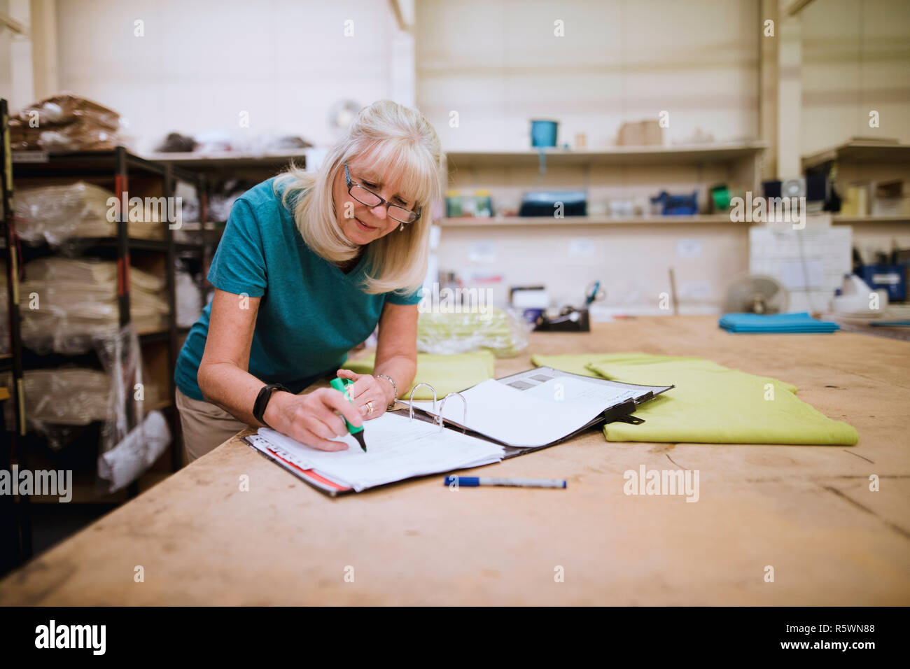 Businesswoman Doing Paperwork In Factory Stock Photo