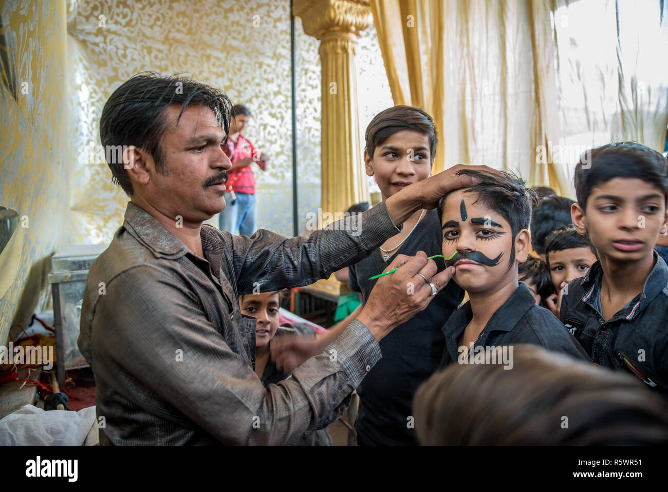A boy being painted moustaches before a performance, Pushkar, Rajasthan, India Stock Photo