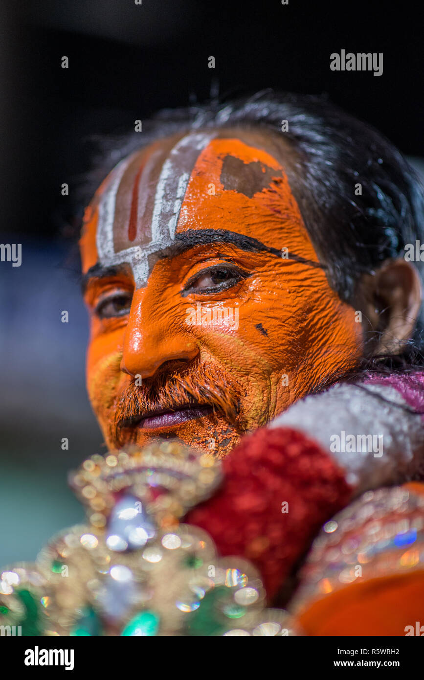 An artist with face painted orange after a performance, Pushkar, Rajasthan, India Stock Photo