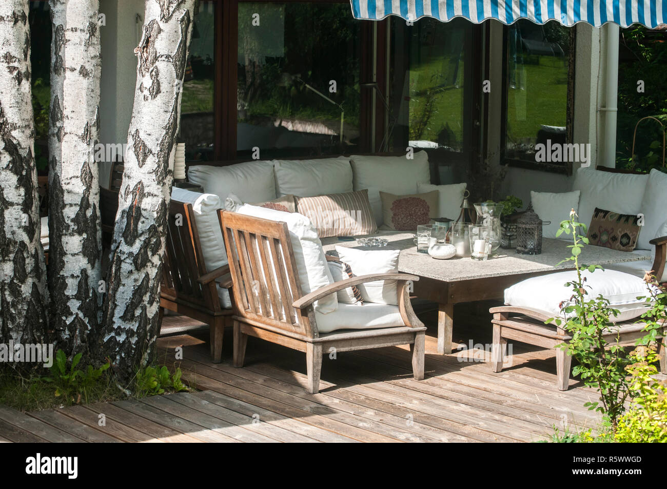 Home garden wooden furniture with table, chairs and cushions on wooden