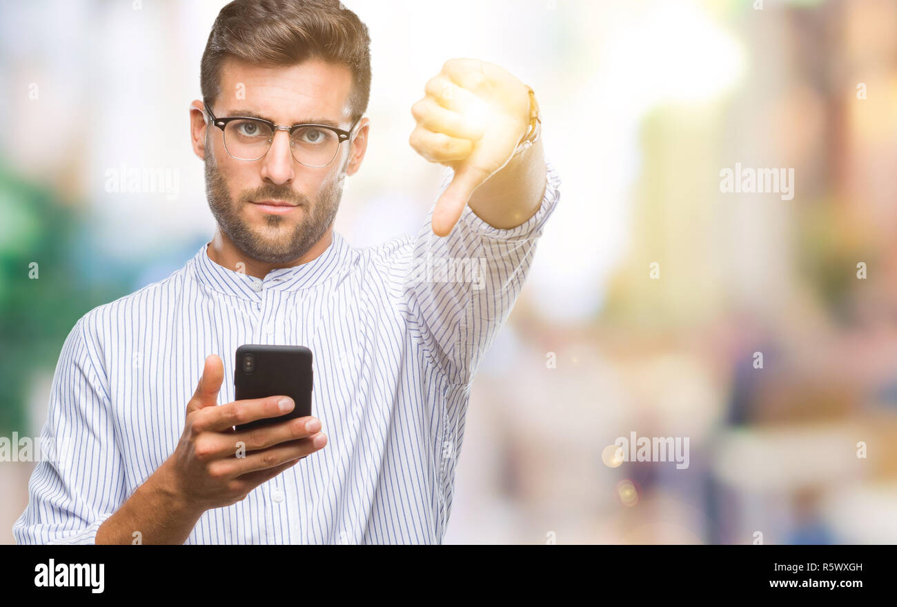 Young handsome man texting using smartphone over isolated background ...