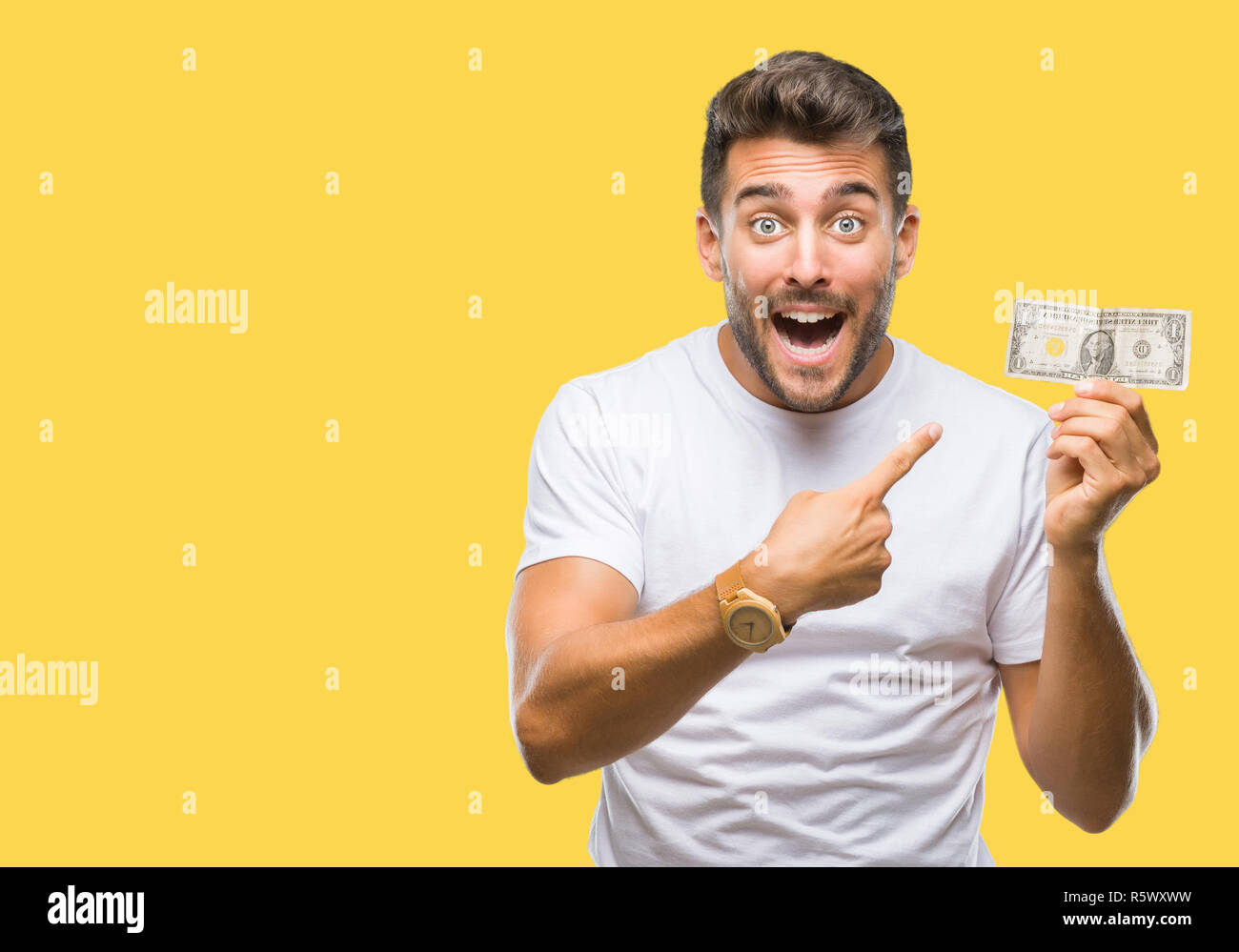 Young handsome man holding dollars over isolated background very happy ...