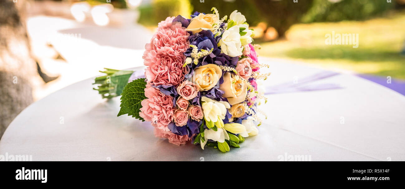 A wedding bouquet with a variety of flowers and lots of colors.Wedding bouquet of brides on table Stock Photo