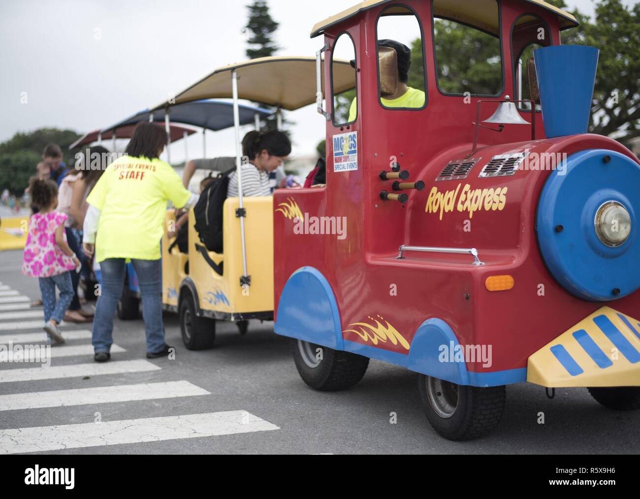 Children and families ride a train at the “Kiddie Land” section of the Eggsplosion event April 15, 2017, at Kadena Air Base, Japan. The 18th Force Support Squadron coordinated and worked together with Marine Corps Community Services on Okinawa to supply entertainment for service members, civilians, and their families during Eggsplosion. Stock Photo