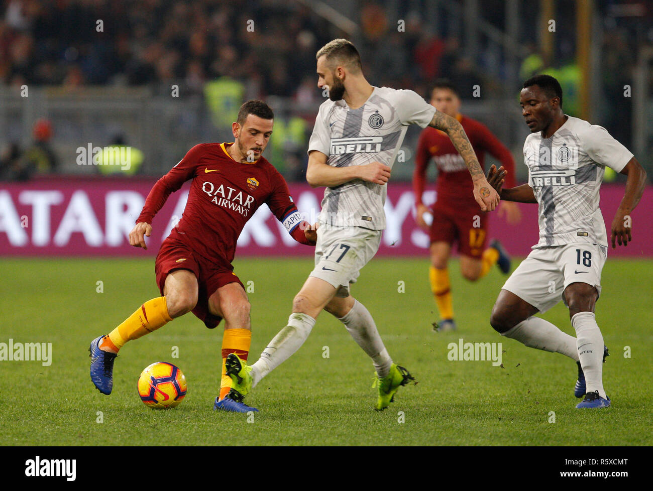 Rome, Italy. 2nd Dec, 2018. Roma's Alessandro Florenzi, left, is challenged by Inter's Marcelo Brozovic, left, and Kwadwo Asamoah during the Serie A soccer match between Roma and Inter at the Olympic Stadium. Credit: UPDATE IMAGES/ Alamy Live News Stock Photo