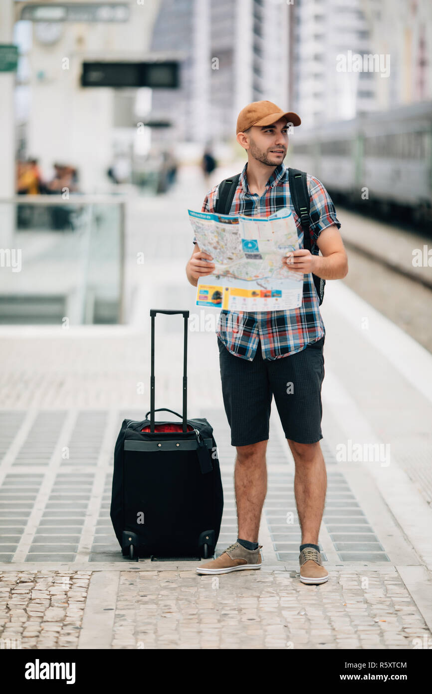 Tourist backpacker using map to travel at train station Stock Photo
